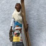 A refugee woman stands desolate cling to a dead tree illustrating Where Next?