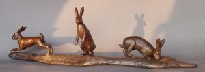 A bronze sculpture of a startled hare