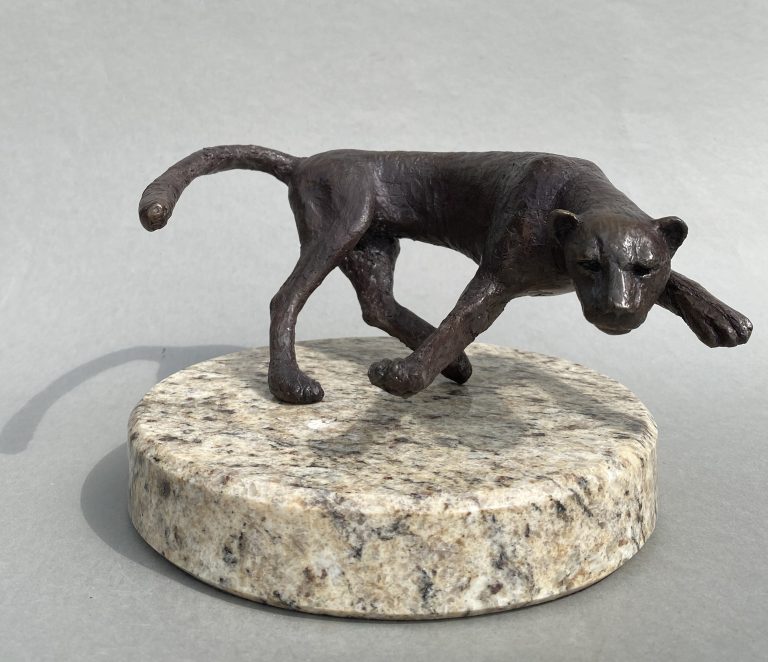 A bronze turning cheetah mounted on marble clicking to details