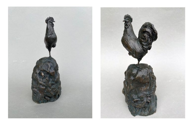 A bronze sculpture of two views of a cockerel on a dung heap