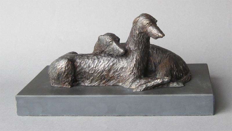 A bronze sculpture of a pair of deerhounds on slate
