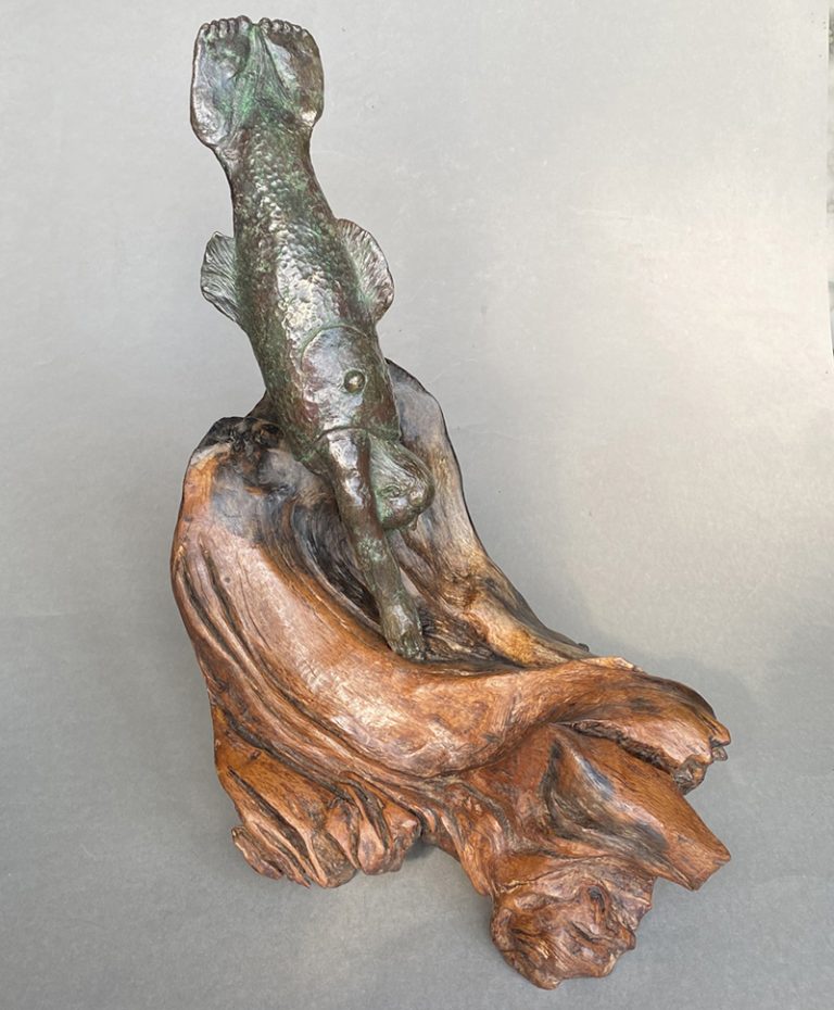 Bronze sculpture of diving figure on oak